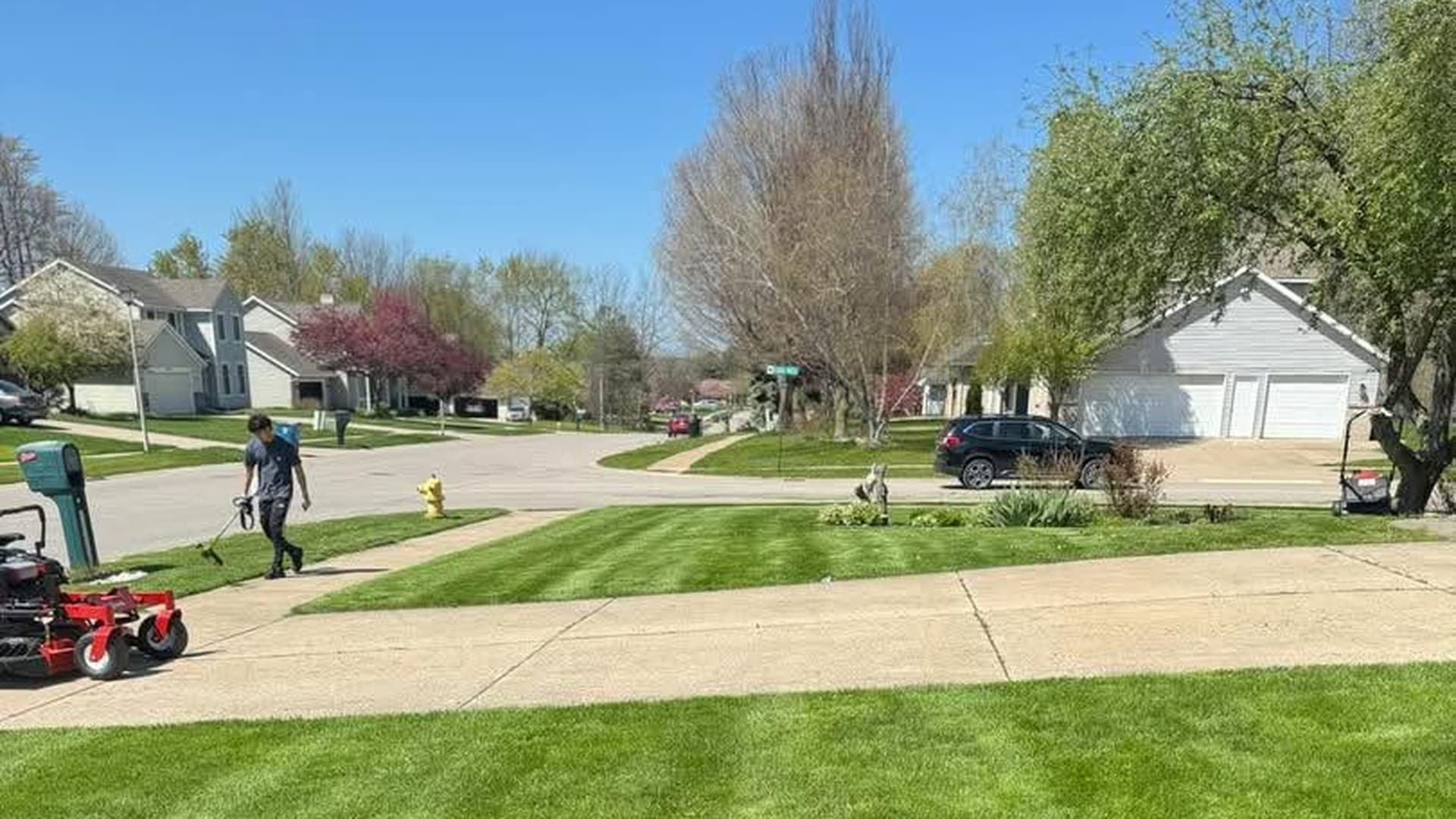 Lawn And Order crew finishing a freshly striped residential lawn in West Michigan